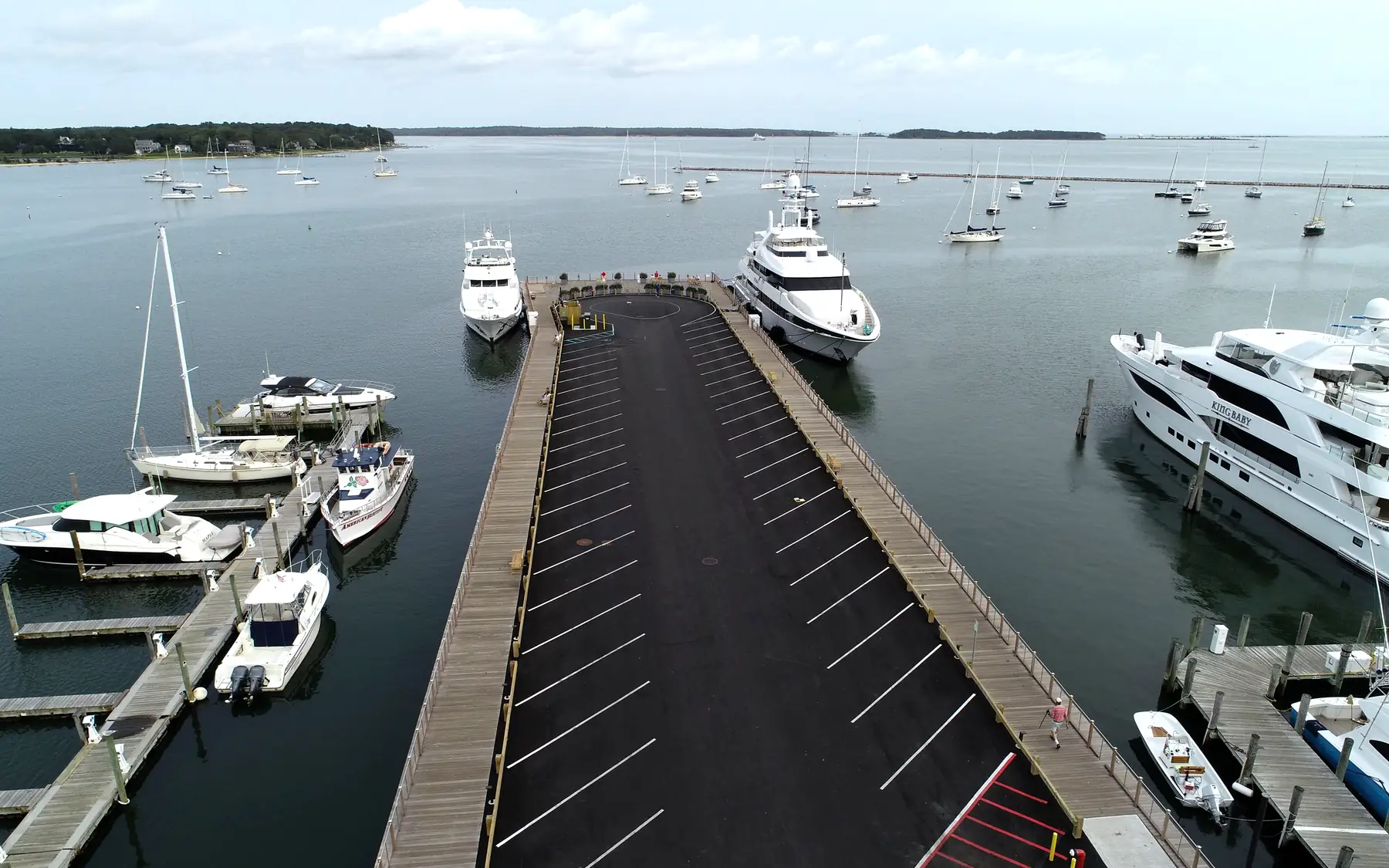 Drone aerial view looking down Sag Harbor Long Wharf toward moored yachts for Lite Yachting Hamptons yacht care